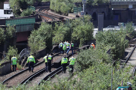 Police officers search near to where three people were found dead on a section railway track in south London, Britain, June 18, 2018. REUTERS/Simon Dawson