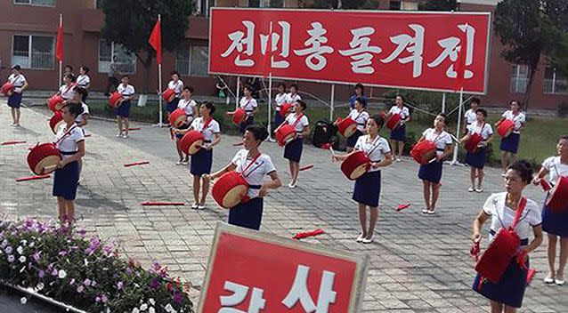 Ladies who encourage workers on the way to work. Source: Caters News Agency