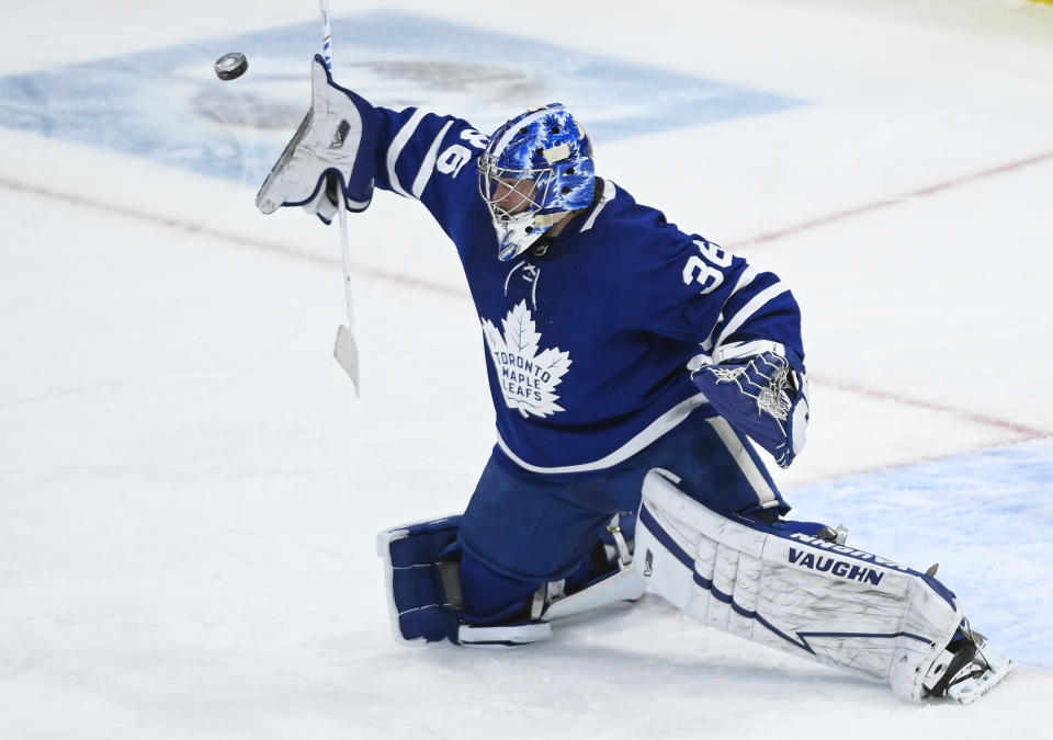 Toronto Maple Leafs goaltender Jack Campbell (36) makes a blocker save against the Calgary Flames during first-period NHL hockey game action in Toronto, Saturday, March 20, 2021. (Nathan Denette/The Canadian Press via AP)