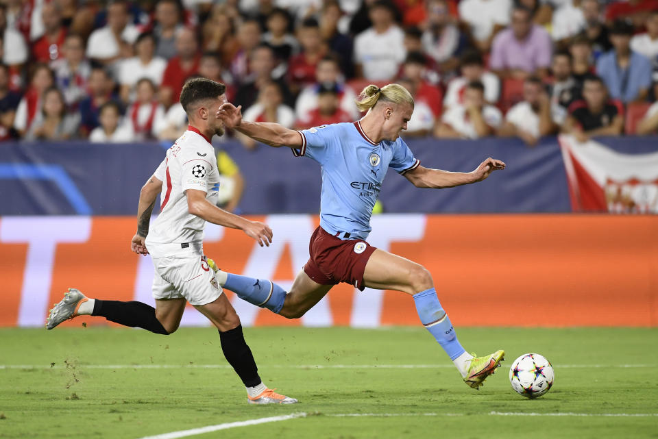 Manchester City's Erling Haaland, right, attempts a shot during the group G Champions League soccer match between Sevilla and Manchester City in Seville, Spain, Tuesday, Sept. 6, 2022. (AP Photo/Jose Breton)