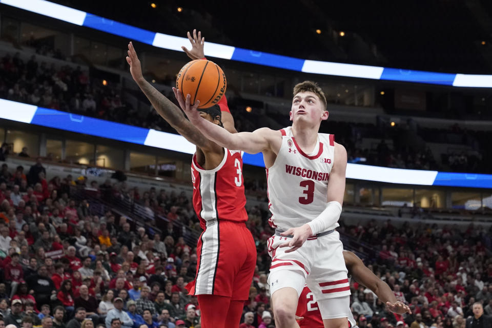 Wisconsin's Connor Essegian drives to the basket past Ohio State's Eugene Brown III during the second half of an NCAA college basketball game at the Big Ten men's tournament, Wednesday, March 8, 2023, in Chicago. Ohio State won 65-57. (AP Photo/Charles Rex Arbogast)