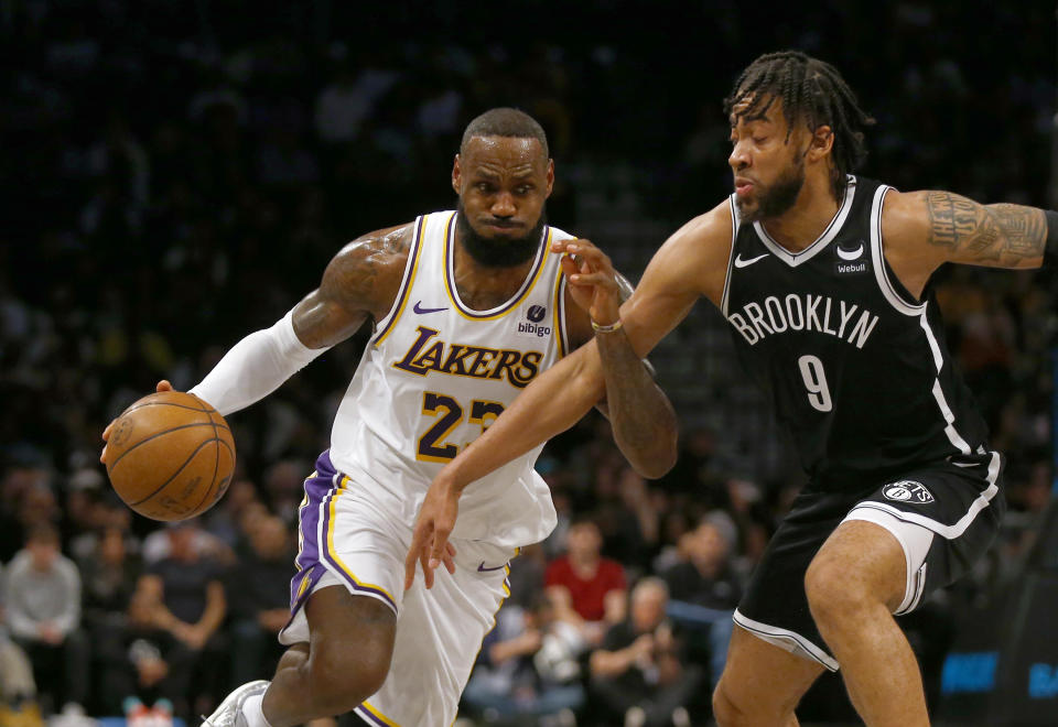 Los Angeles Lakers forward LeBron James, left, drives against Brooklyn Nets forward Trendon Watford during the first half of an NBA basketball game Sunday, March 31, 2024, in New York. (AP Photo/John Munson)