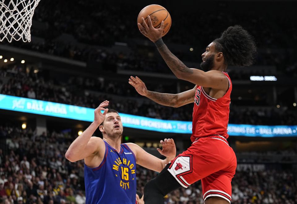 Chicago Bulls guard Coby White (0) goes up for a shot against Denver Nuggets center Nikola Jokic (15) during the third quarter of an NBA basketball game, Saturday, Nov. 4, 2023, in Denver. (AP Photo/Jack Dempsey)