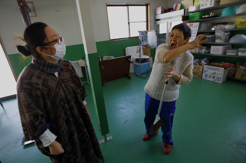 In this Monday, March 3, 2014 photo, Takako Sato, 62, right, a hearing impaired survivor of the March 11, 2011 tsunami, talks in sign language with Atsuko Takeshita, manager of Huck's House, a vocational center for the disabled, in Tanohata, Iwate Prefecture, northeastern Japan. The wait is just too much for Sato, who after nearly three years is fed up with the temporary housing. Hearing impaired, she waves her hands repeatedly to convey how her house was swept away, and holds them joined as if in prayer to express her frustrations. (AP Photo/Junji Kurokawa)