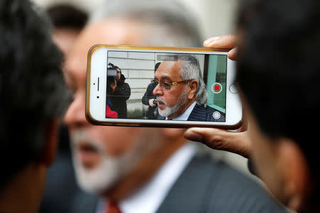 A man films Vijay Mallya on his mobile phone as he has a break outside the court house before his extradition case at Westminster Magistrates Court, in London, Britain, December 10, 2018. REUTERS/Peter Nicholls