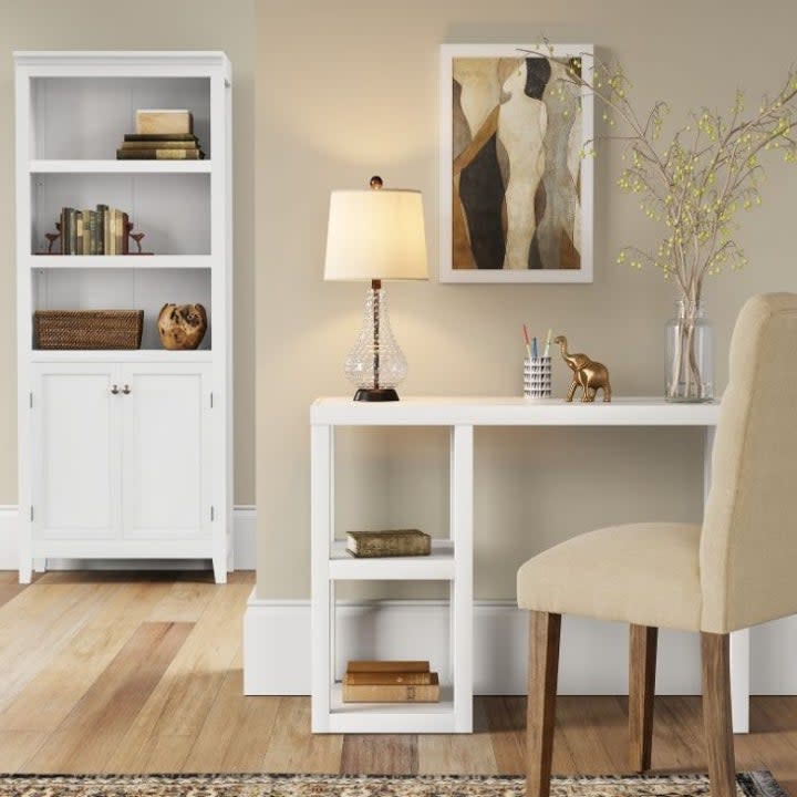 White bookshelf and desk in beige room