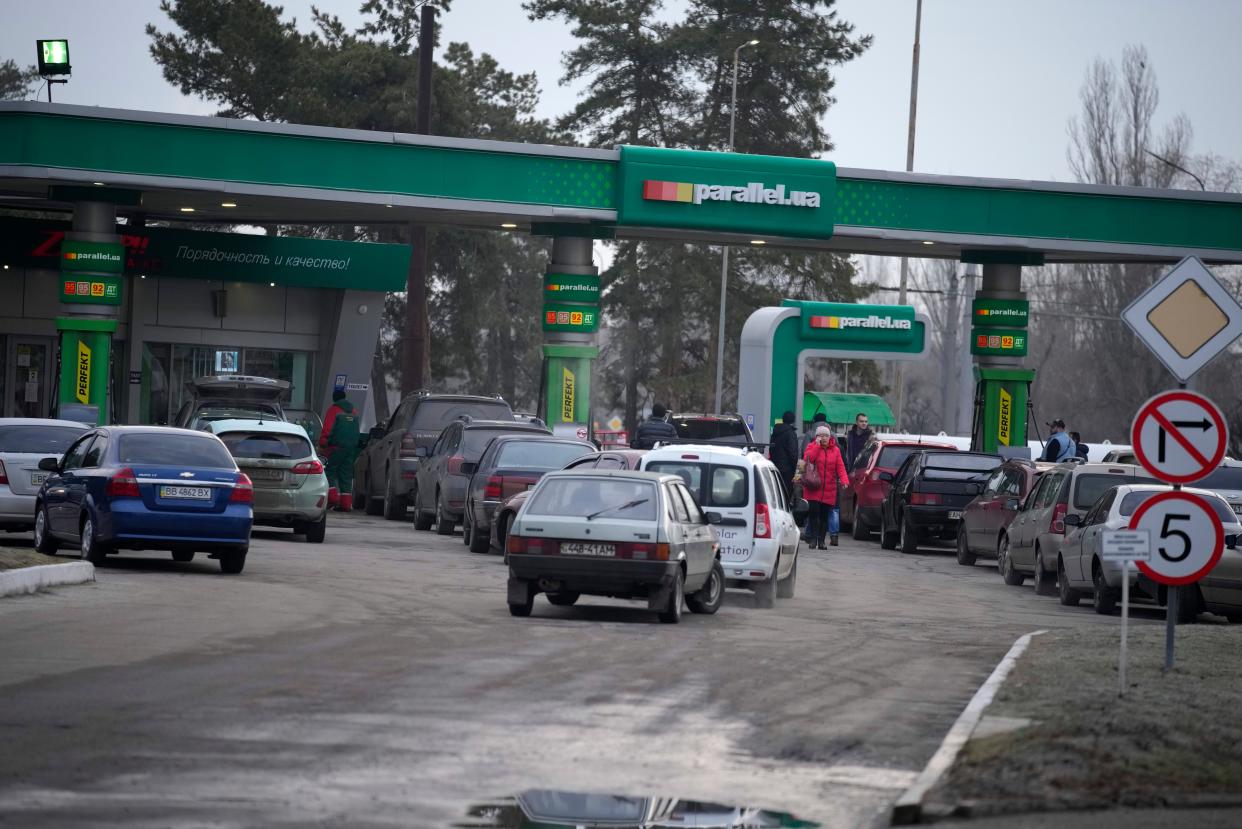 People queue for fuel at a gas station in Sievierodonetsk, the Luhansk region, eastern Ukraine, Thursday, Feb. 24, 2022. Russian President Vladimir Putin on Thursday announced a military operation in Ukraine and warned other countries that any attempt to interfere with the Russian action would lead to "consequences you have never seen."