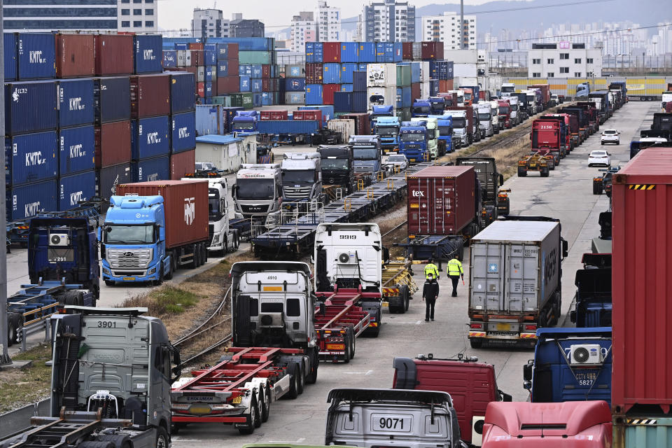 Trucks are parked next to containers at the Inland Container Depot in Uiwang, South Korea, Monday, Nov. 28, 2022. South Korea’s government issued an order Tuesday for some of the thousands of striking truck drivers to return to work, insisting that their nationwide walkout over freight fare issues is hurting an already weak economy. (Kim Jong-taek/Newsis via AP)