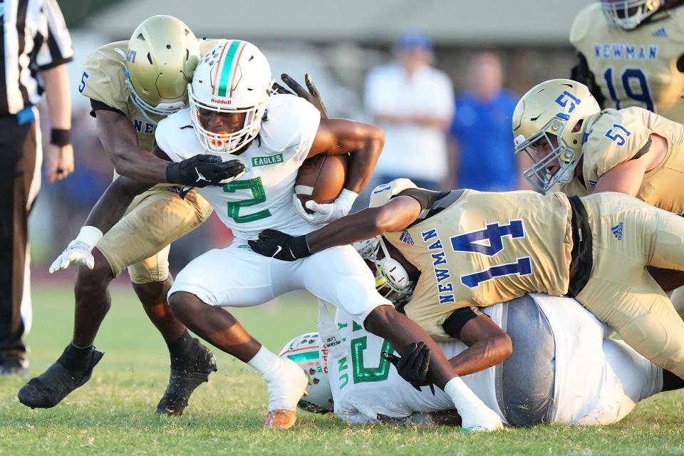 Damarion Alberic (2) of Atlantic High picks up a short gain as Max Redmon (5) and Devon Byrd (14) of Cardinal Newman close in for the tackle in the second quarter on Friday, September 22, 2023 in West Palm Beach.