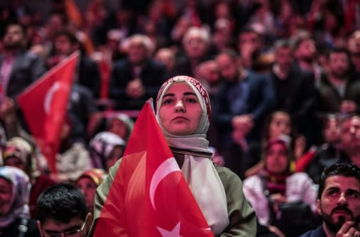 A supporter of the Turkish President stands for the national anthem before his speech in Istanbul, on May 6, 2018