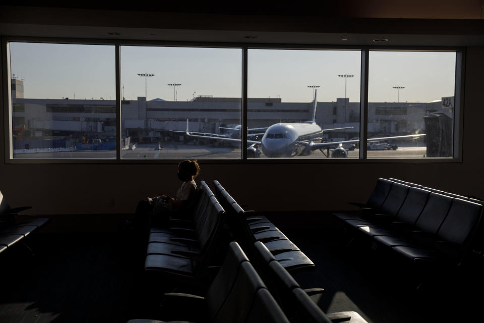 A passenger sits in Terminal 4 at Los Angeles International Airport