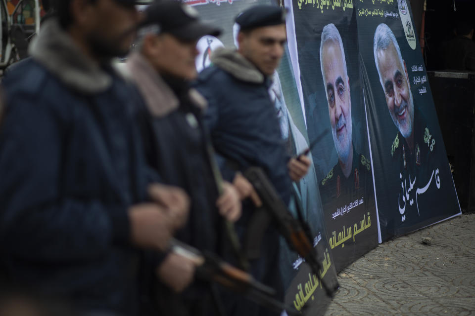 Palestinian Hamas policemen stand guard next to posters of Qassem Soleimani, the Iran's head of the Quds Force who was killed in a US drone strike early Friday, in front of a mourning tent held by Palestinian factions for Sleimani in Gaza City, Saturday, Jan 4, 2020. (AP Photo/Khalil Hamra)