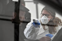 FILE - In this on Tuesday, March 10, 2020 file photo, a member of the medical staff measures the temperature of a traveller at a autobahn park place near Gries am Brenner, Austria near the border crossing with Italy. Europe is taking a big step toward a new normality after the coronavirus outbreak as many countries open up their borders to fellow Europeans – but exceptions remain, and it remains to be seen how many will use their rediscovered freedom to travel. (AP Photo/Kerstin Joensson, file )