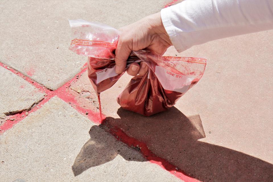 Red sand being spread across the sidewalks down Central Ave.