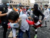 Iraqi demonstrators carry away a wounded man during the ongoing anti-government protests in Baghdad