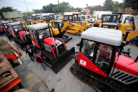 Government workers inspect construction equipment donated by China, that will aid in the rehabilitation of the war-torn Marawi city, in the port of Iligan city, southern Philippines October 19, 2017. REUTERS/Romeo Ranoco