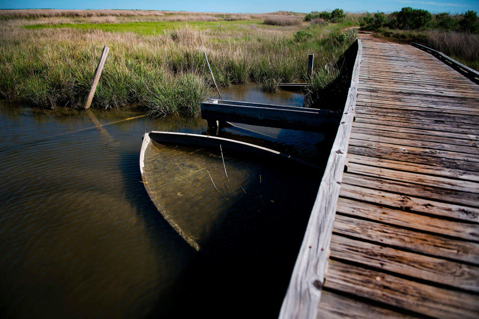 <p>A submerged boats rests under a bridge in Tangier, Virginia, May 15, 2017, where climate change and rising sea levels threaten the inhabitants of the slowly sinking island.<br> (Jim Watson/AFP/Getty Images) </p>