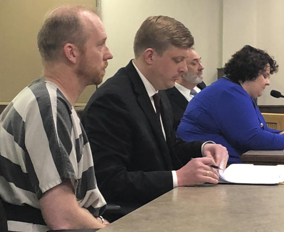 Chad Isaak, left, appears in court April 5, 2019, in Mandan, North Dakota. A judge set a $1 million bond for Isaak who is accused of killing four people, citing the "heinous nature" of the alleged crimes. Isaak, a chiropractor and Navy veteran, faces four murder charges in the slayings Monday in the city of Mandan. The victims' bodies were found at the property management company where they worked. (AP Photo/James MacPherson)