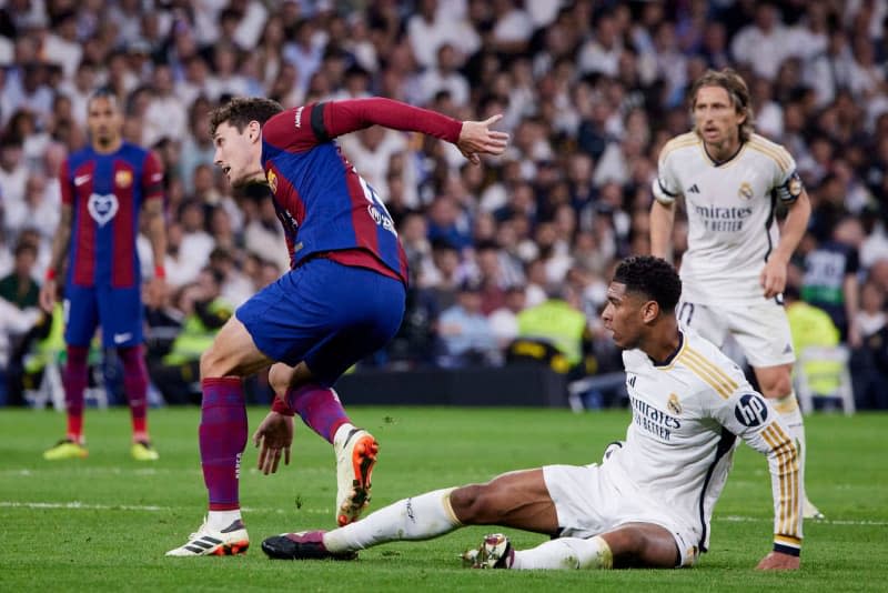 Real Madrid's Jude Bellingham and Barcelona's Andreas Christensen battle for the ball during the Spanish Primera Division La Liga soccer match between Real Madrid and FC Barcelona at Santiago Bernabeu stadium. Ruben Albarran/ZUMA Press Wire/dpa