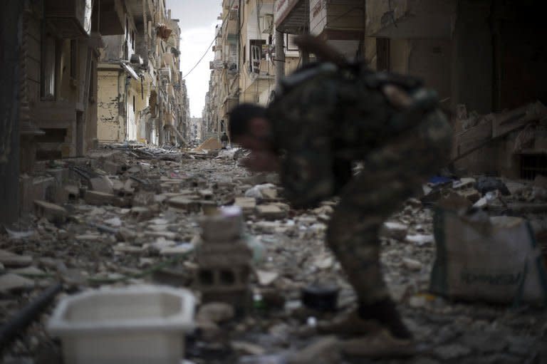 A Syrian opposition fighter rubs dust from his face in the Jabilleh neighbourhood in the eastern city of Deiz Ezzor, during clashes with regime forces on February 16, 2013