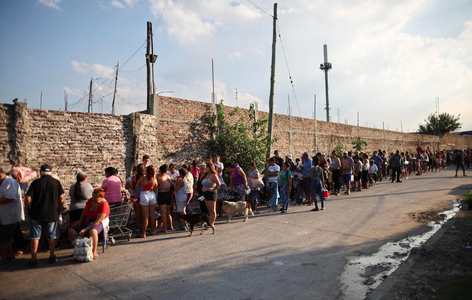 La gente hace fila para recibir una bolsa de comida de caridad, afuera de la ONG Sal de la tierra, en Villa Fiorito, un barrio de clase trabajadora en las afueras de Buenos Aires, Argentina, el 27 de febrero de 2024. REUTERS/Agustin Marcarian/File Photo