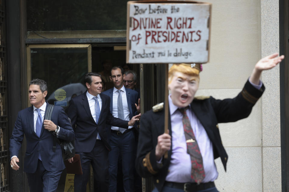 Ein Demonstrant am Rande des Prozesses in Washington DC, im Hintergrund verlassen Trumps Anwälte das Gerichtsgebäude. (Bild: Win McNamee/Getty Images)