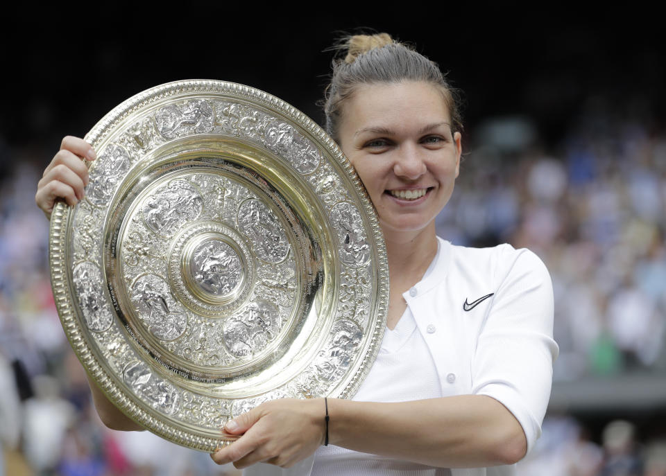 FILE - Romania's Simona Halep holds the trophy after defeating Serena Williams in the women's singles final of the Wimbledon Tennis Championships in London, July 13, 2019. Two-time Grand Slam champion Simona Halep has been suspended from professional tennis for four years for alleged doping violations, the International Tennis Integrity Agency said Tuesday, Sept. 12, 2023. (AP Photo/Ben Curtis, File)