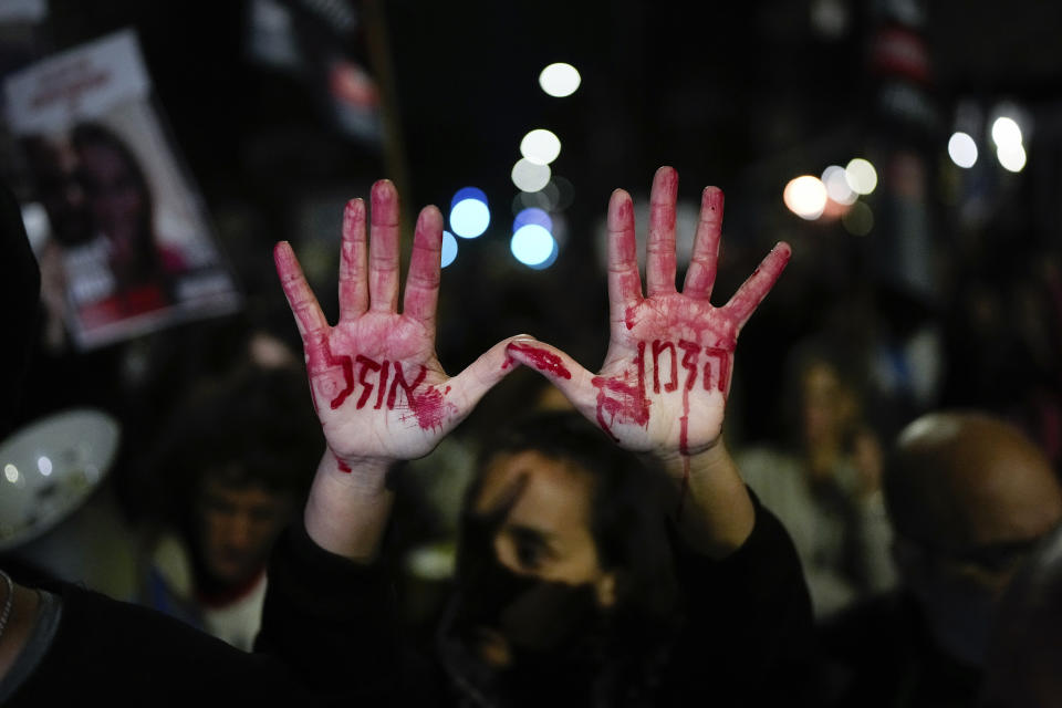 Relatives and supporters of the Israeli hostages held in the Gaza Strip by the Hamas militant group attend a protest calling for their release outside the Knesset, Israel's parliament, in Jerusalem, Monday, Jan. 22, 2024. Hebrew on the hands with fake blood reads, "Time is running out". (AP Photo/Ohad Zwigenberg)