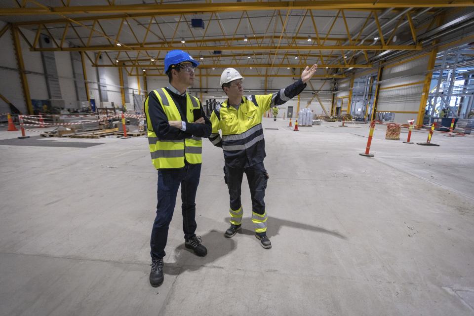 Lars Nermoen, left, head of communications, and Ragnar Johnsson, factory manager, talk in the facility for the Norwegian company Nel in Heroya, Norway, on April 20, 2023. Nel makes devices that take water and split it into hydrogen and oxygen, known as electrolyzers, as well as fueling stations. The company announced plans Wednesday, May 3, to build a massive new plant in Michigan as it works with General Motors to drive down the cost of hydrogen. (AP Photo/Trond R. Teigen)