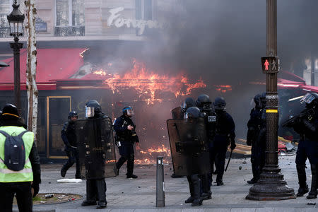 Paris famed restaurant Fouquet's burns on the Champs-Elysees during a demonstration by the "yellow vests" movement in Paris, France, March 16, 2019. REUTERS/Benoit Tessier