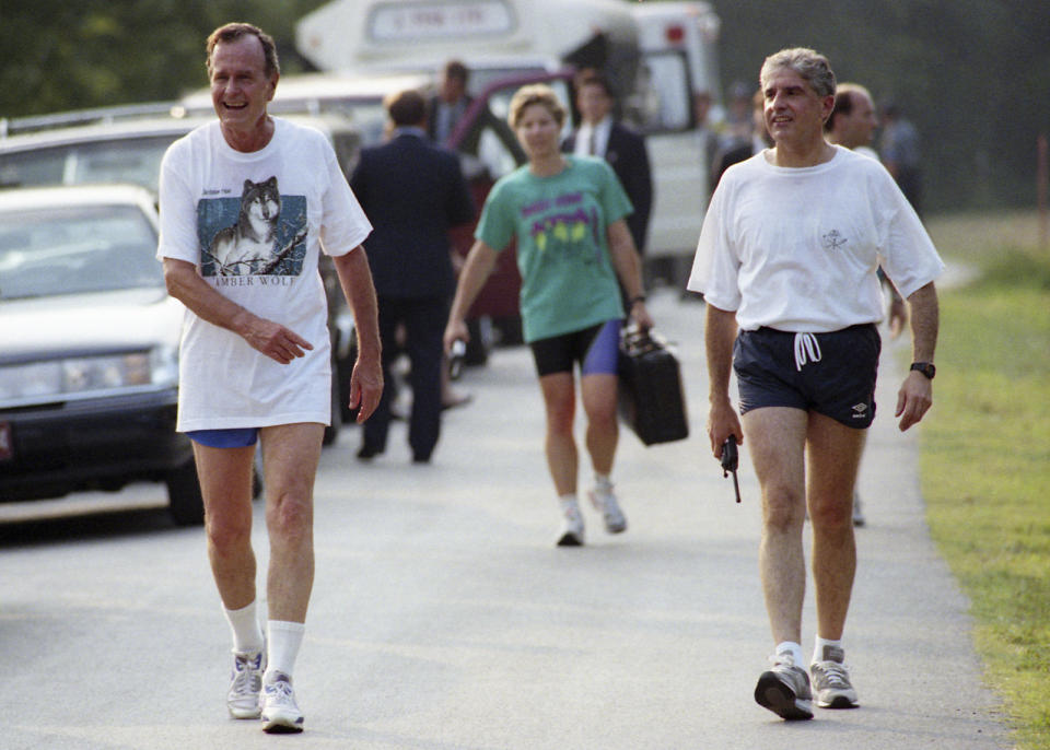 In this photo obtained by the National Security Archive from the George H. B. Bush Presidential Library, Maj. Michelle D. Johnson, White House Air Force aide, carries the Presidential Emergency Satchel behind President George H. W. Bush in Branson, Mo., on Aug. 21, 1992. (George H. B. Bush Presidential Library/National Security Archive - nsarchive.gwu.edu via AP)
