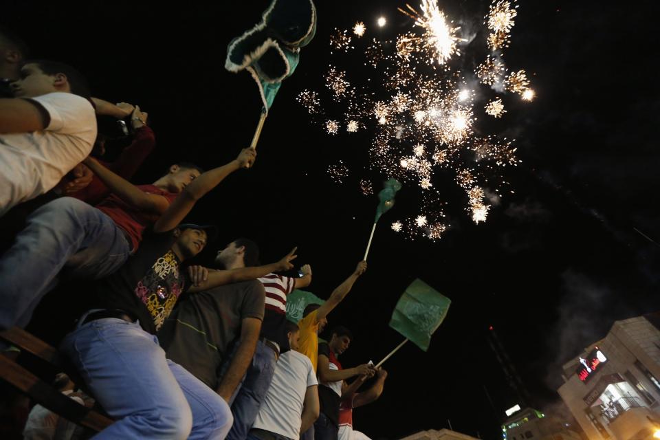 Palestinians release fireworks as they celebrate what they said was a victory by Palestinians in Gaza over Israel following a ceasefire, in the West Bank city of Ramallah August 26, 2014. A ceasefire agreement between Israel and the Palestinians aimed at ending their seven-week conflict in Gaza went into effect on Tuesday and joyous Palestinians streamed into the streets of the battered enclave to celebrate. (REUTERS/Mohamad Torokman)