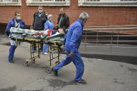 Medical staff carry an injured person on a stretcher at the emergency department of the First Republican Clinical hospital to evacuate to Moscow, in Izhevsk, Russia, Tuesday, Sept. 27, 2022. The plane of the Ministry of Emergency Situations will deliver victims of the shooting at school No. 88 in Izhevsk to Moscow hospitals. This was stated by the Presidential Commissioner for Children's Rights Maria Lvova-Belova. According to officials, 11 children were among those killed in the Monday morning shooting in School No. 88 in Izhevsk, a city 960 kilometers (600 miles) east of Moscow.(AP Photo/Dmitry Serebryakov)