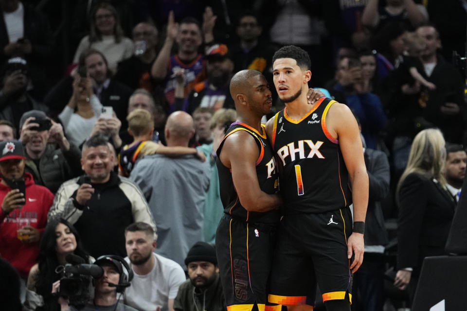 Phoenix Suns guard Chris Paul embraces guard Devin Booker (1) after Booker made a basket during the second half of an NBA basketball game against the New Orleans Pelicans, Saturday, Dec. 17, 2022, in Phoenix. The Suns defeated the Pelicans 118-114. (AP Photo/Matt York)