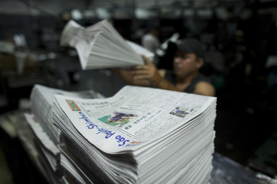 In this Dec. 21, 2018 photo, recently printed editions of the Sao Paulo Shimbun Japanese newspaper are stacked into piles before delivery in Sao Paulo, Brazil. For decades Sao Paulo Shimbun, which printed its last edition on Jan. 1, 2019, served as the main reference point for Japanese living in the South American country. (AP Photo/Victor R. Caivano)