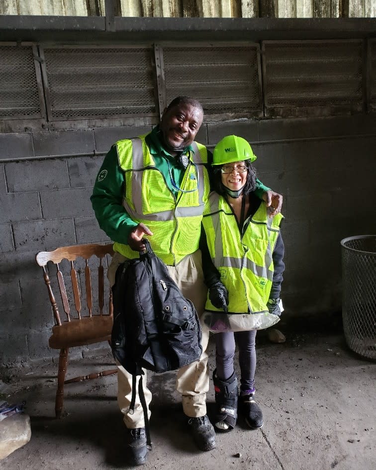 A New York City Department of Sanitation worker (left) helped this woman retrieve her lost backpack. DSNY