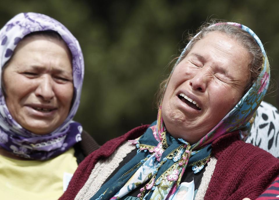 Women mourn during the funeral of a miner who died in a fire at a coal mine, at a cemetery in Soma, a district in Turkey's western province of Manisa May 15, 2014. Loudspeakers broadcast the names of the dead and excavators dug mass graves in this close-knit Turkish mining town on Thursday, while protesters gathered in major cities as grief turned to anger following the country's deadliest industrial disaster. Rescuers were still trying to reach parts of the coal mine in Soma, 480 km (300 miles) southwest of Istanbul, almost 48 hours after fire knocked out power and shut down the ventilation shafts and elevators, trapping hundreds underground. At least 282 people have been confirmed dead, mostly from carbon monoxide poisoning, and hopes are fading of pulling out any more alive of the 100 or so still thought to be inside. REUTERS/Osman Orsal (TURKEY - Tags: DISASTER ENERGY OBITUARY)