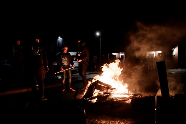 French prison guards, seen here by a burning barricade in Nanterre, began a nationwide strike earlier this week over security concerns