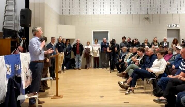 A screenshot of a video recording of a public meeting on Tuesday evening when Premier Tim Houston spoke to a crowd of hundreds of people in the Heatherton Community Centre in Antigonish County, N.S., about a proposed consolidation of the area's town and county. (Facebook/ Let Antigonish Decide - image credit)