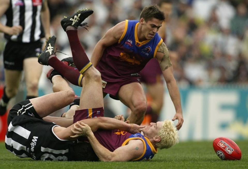 Jason Akermanis is tackled by Paul Licuria in the 2002 AFL grand final.