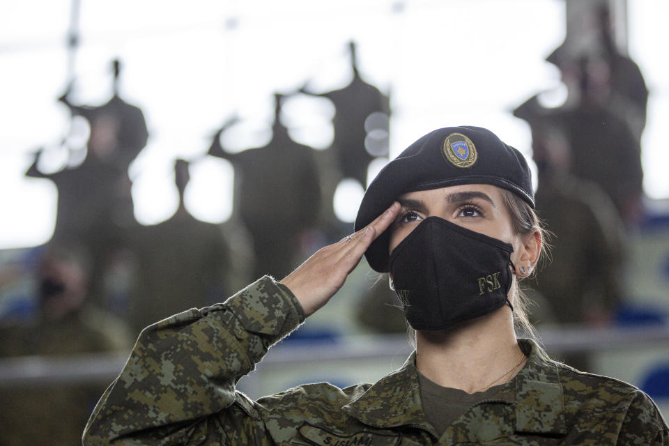 A Kosovo Security Force (KSF) member wearing a face mask salutes, during a peacekeeping mission deployment ceremony held at the army barracks in Pristina, Tuesday, March 9, 2021. Kosovo is sending a military platoon to Kuwait, its first ever involvement in an international peacekeeping mission. A ceremony was held Tuesday at the army barracks in the capital, Pristina, with the presence of top country leaders and western military attaches. Kosovo is sending the military unit following a request from the U.S. Central Command. (AP Photo/Visar Kryeziu)