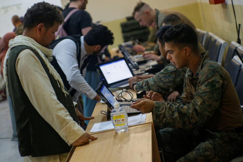 us soldiers look at computers, checking people in