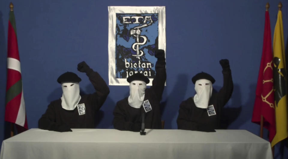 FILE - In this file image made from video provided on Oct. 20, 2011, masked members of the Basque separatist group ETA hold up their fists in unison following a news conference at an unknown location. Josu Urrutikoetxea, the last known chief of ETA, the now-extinct Basque separatist militant group, goes on trial Monday Oct. 19, 2020 in Paris for terrorism charges that he deems “absurd” because of his role in ending a conflict that claimed hundreds of lives and terrorized Spain for half a century. (Gara via AP, File)