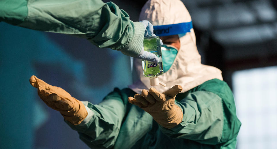 A nurse uses hand sanitiser to protect herself from coronavirus