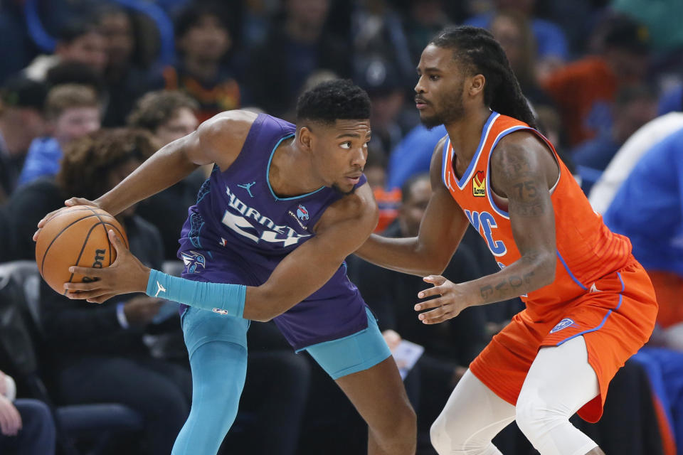 Charlotte Hornets forward Brandon Miller, left, holds the ball as Oklahoma City Thunder guard Cason Wallace, right, defends during the first half of an NBA basketball game, Friday, Feb. 2, 2024, in Oklahoma City. (AP Photo/Nate Billings)