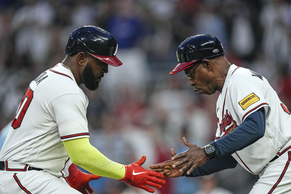Atlanta Braves' Marcell Ozuna, left, celebrates with third base coach Ron Washington while heading for home on a two-run home run against the Los Angeles Dodgers during the fifth inning of a baseball game Wednesday, May 24, 2023, in Atlanta. (AP Photo/John Bazemore)