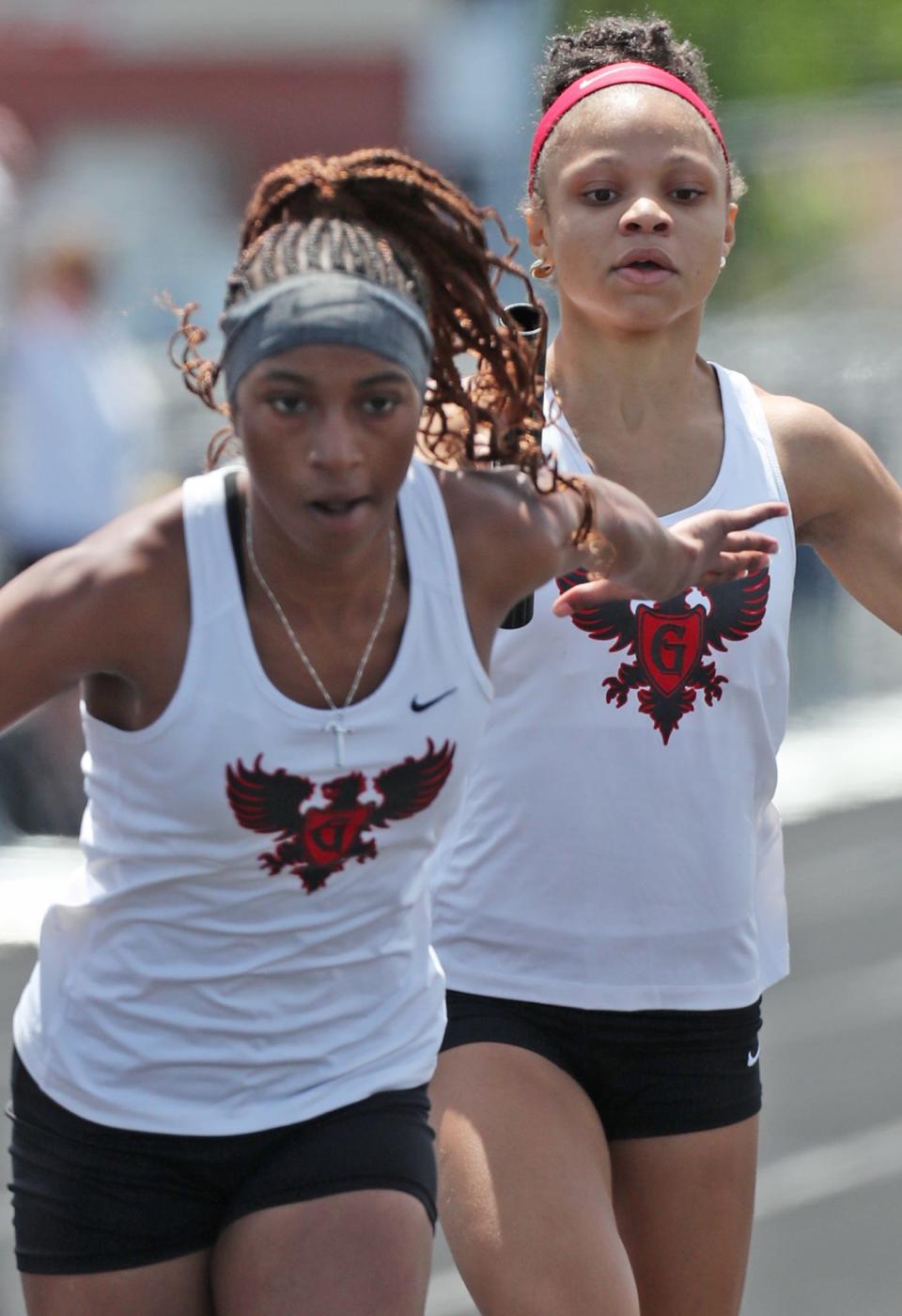 Buchtel's Cha'Mere Hullum takes the baton from Tianna Burton in the 800 relay, which they won at the 2023 Division II regional track meet at Austintown Fitch.