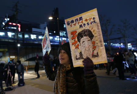 A protester holds banners depicting Japan's Prime Minister Shinzo Abe as she shouts during an anti-nuclear rally in front of the headquarters of Tokyo Electric Power Co (TEPCO), the operator of the tsunami-crippled Fukushima Daiichi nuclear plant, a day before the five-year anniversary of the disaster, in Tokyo, Japan, March 10, 2016. REUTERS/Yuya Shino