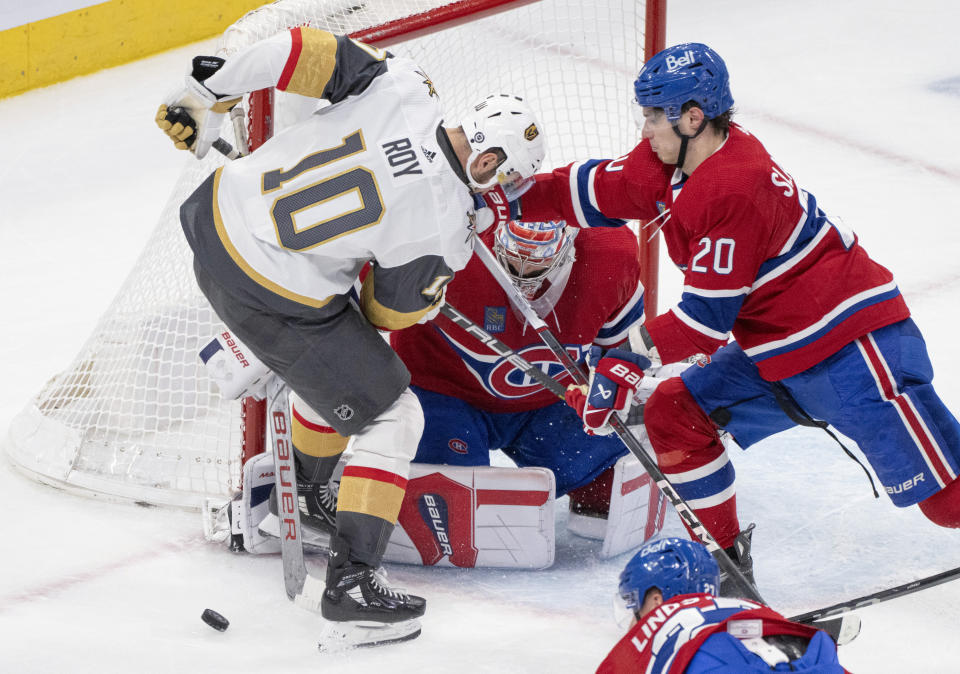 Vegas Golden Knights' Nicolas Roy (10) and Montreal Canadiens' Juraj Slafkovsky (20) vie for a rebound in front of Canadiens goaltender Cayden Primeau (30) during the second period of an NHL hockey game Thursday, Nov. 16, 2023, in Montreal. (Christinne Muschi/The Canadian Press via AP)