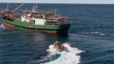 A still image shows a boat with Russian border guards sailing towards a North Korean vessel to detain it and crew members for poaching in waters that Moscow considers its exclusive economic zone